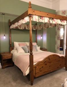 a bedroom with a canopy bed with a wooden frame at Unique Georgian Splendour at The Old Ballroom sleeps 2 with sofabed 4 add The Studio at extra cost to sleep 2 more in Norwich