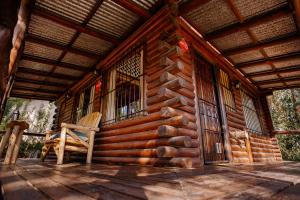 Cabaña de madera con una silla en el porche en Namasté Cabaña Tandil en Tandil