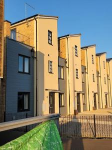 a view of a row of buildings with a green tarp at New build home with WI-FI, Smart TV, dedicated office floor, large terrace and Free parking in Milton Keynes