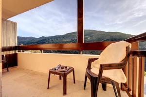 a chair and a table on a balcony with a view at Le Lou&My à Valmeinier 1800 in Valmeinier