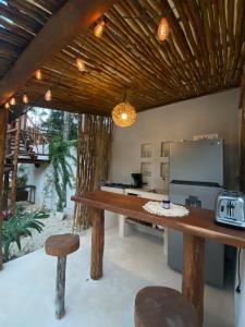 una cocina con una gran mesa de madera y una barra en Lodge Tzunum Jade en Tulum