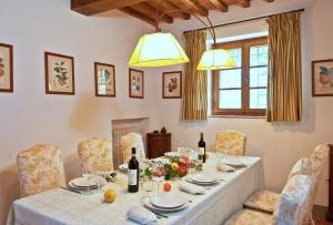 a dining room with a table with wine bottles and chairs at Casavecchia 12 by Salogi Villas in Volpaia