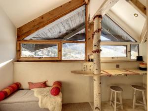 - un salon avec un canapé et une fenêtre dans l'établissement Cocon en face du Grands Montets, à Chamonix-Mont-Blanc