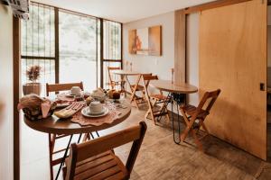 a dining room with tables and chairs and a window at CasAlta Pousada in Bento Gonçalves