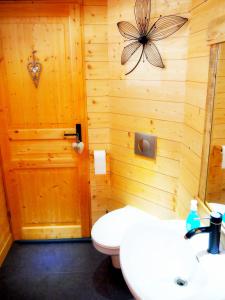 a bathroom with a wooden wall with a toilet and a sink at Appartement Maison Vosgienne La Bresse Centre in La Bresse