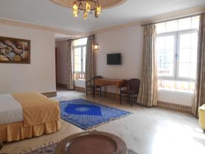 a bedroom with a bed and a table and a desk at Dar Nador in Nador