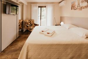 um quarto com uma cama com duas toalhas em CasAlta Pousada em Bento Gonçalves
