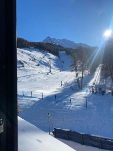 uma pista coberta de neve com pessoas num teleférico em La finestra sulla montagna - The window on the Mountain em Pila