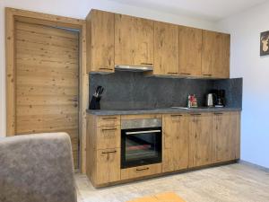 a kitchen with wooden cabinets and a stove at WALD-Apart am Rosenhof in Nauders