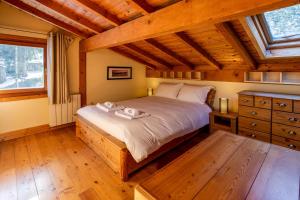 夏慕尼白朗峰的住宿－Chalet des Favrands，一间带一张大床的卧室,位于一个拥有木制天花板的房间
