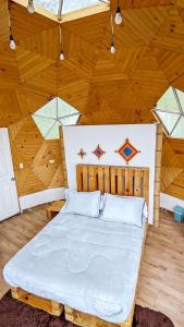 a bedroom with a large bed in a wooden ceiling at Glamping Reserva del Roble in La Vega