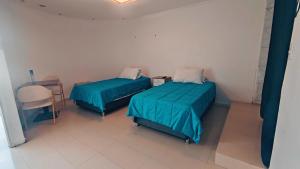 um quarto com duas camas, uma mesa e uma cadeira em Hotel Flamingo Express em Iquique