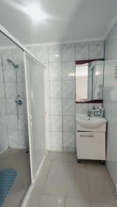 een witte badkamer met een douche en een wastafel bij Hotel Flamingo Express in Iquique