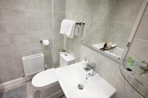 a bathroom with a white toilet and a sink at Luxury 4 Bed House with Gated Parking in the Heart of Birmingham! in Birmingham