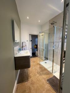 a bathroom with a glass shower and a sink at 10 Grove St - Bath Holiday Suites in Bath