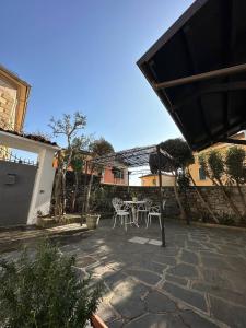 a patio with a table and chairs in a yard at Casa Sasso e Legno in Omegna