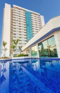 una piscina frente a un gran edificio en Flat Hotel Samba Barra Jeunesse Arena Projac Rio Centro, en Río de Janeiro