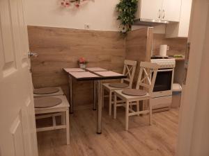 a small kitchen with a table and four chairs at Fonyódi Centrum Apartman in Fonyód