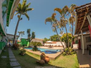 un patio del complejo con piscina y palmeras en Pousada Terra Nostra, en Prado