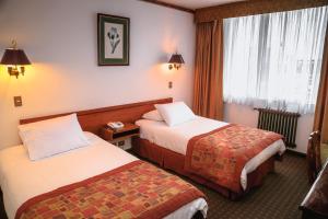 蓬塔阿雷納斯的住宿－HOTEL LOS NAVEGANTES，酒店客房设有两张床和窗户。