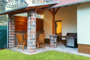 un patio con sedie e un grill in una casa di Prázdninový dům Valdík a Loket
