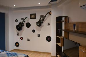 Eine Wand mit einem Haufen Gitarren an der Wand in der Unterkunft M@D Music Apartment in Timişoara
