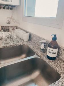 - un évier de cuisine avec une bouteille de savon à côté dans l'établissement Espectacular departamento a metros del mar, à Puerto Madryn 7 autres photos