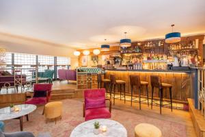 a restaurant with a bar and tables and chairs at The Berkeley Square Hotel Bristol in Bristol