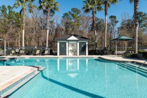 a swimming pool with a gazebo and palm trees at Kasa Southside Jacksonville in Jacksonville