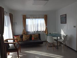 uma sala de estar com um sofá e uma mesa em Atardeceres Tongoy - Cabaña 4 personas condominio privado Tanguemar em Coquimbo