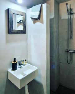a white bathroom with a sink and a shower at Diana in Ermoupoli