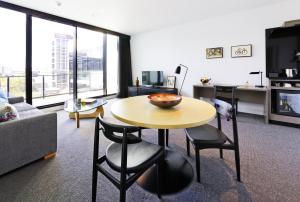 - un salon avec une table, des chaises et un canapé dans l'établissement Alpha Mosaic Hotel Fortitude Valley Brisbane, à Brisbane