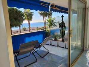 a balcony with chairs and a view of the beach at GRAND LARGE Méditerranée in Cagnes-sur-Mer