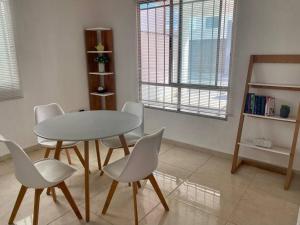 comedor con mesa blanca y sillas en Casa Aliisa, en Mérida