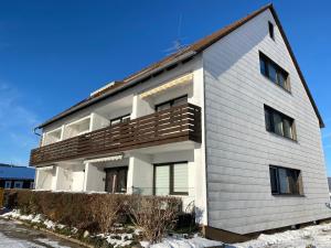 a large white building with a balcony at Ferienwohnung nahe der Skipiste im Fichtelgebirge in Mehlmeisel