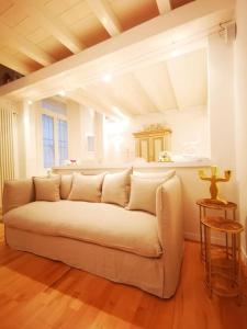 uma sala de estar com um sofá branco num quarto em Gombruti14 Boutique Home em Bolonha