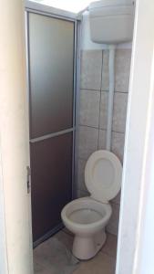 een badkamer met een toilet en een douchecabine bij Pousada Vila di Italia in Cidreira