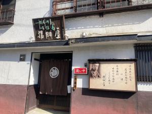 a building with a poster of a man on the side of it at 揚羽屋 小諸駅徒歩2分 1日1組限定 ひとりでも泊まれます Agehaya Historical house Center of the town 2minutes walk from Komoro station in Komoro