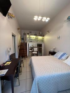 1 dormitorio con cama, mesa y cocina en Hôtel Le Manoir aux Vaches, en Yvetot