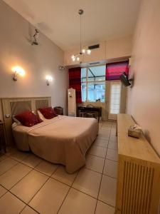 een slaapkamer met een groot bed met rode kussens bij Hôtel Le Manoir aux Vaches in Yvetot