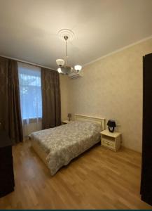 a bedroom with a bed and a large window at Шикарні апартаменти поруч з Майданом in Kyiv