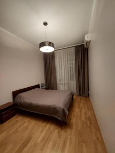 - une chambre avec un lit dans un dortoir doté de parquet dans l'établissement Шикарні апартаменти поруч з Майданом, à Kiev