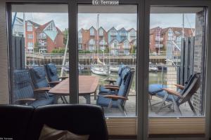 Blick auf eine Terrasse mit Stühlen und einem Tisch in der Unterkunft Marina 22C in Cuxhaven