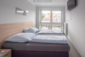 three pillows on a bed in a room with a window at Marina 22C in Cuxhaven