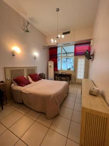 - une chambre avec un grand lit et des oreillers rouges dans l'établissement Hôtel Le Manoir aux Vaches, à Yvetot