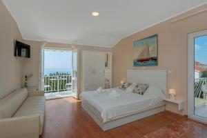 a bedroom with a white bed and a couch at Villa NIKA & KARLO Makarska in Makarska