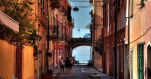two people walking down an alley between buildings at VILLA ROSA CON SPLENDIDA VISTA MARE in Bonassola