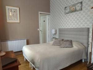 - une chambre avec un lit blanc et une table dans l'établissement La Maison De La Fontaine, Le Beny Bocage, à Le Bény-Bocage