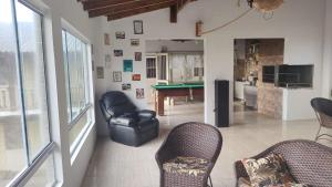 een woonkamer met stoelen en een pooltafel bij Pousada Vila di Italia in Cidreira