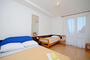 a white room with two beds and a window at Apartments Josko in Gradac